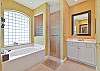 The en-suite spacious bathroom with his and her vanity and separate tub and walk-in shower