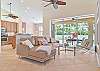 The living features an inviting leather sectional couch and flat screen TV. Sliding doors to the pool area
