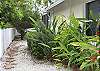 Tropical landscaping lines the path to the private back-yard