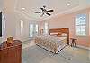 The primary bedroom features a king size bed and flat screen TV. The french doors open up to the pool area