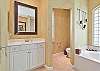The en-suite spacious bathroom with his and her vanity and separate tub and walk-in shower