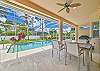 Covered lanai with outdoor dining and lounge chairs