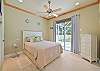 Beach style decorated guest bedroom with Queen size bed, and sliding doors to the screened in pool area.