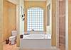 The en-suite spacious bathroom with his and her vanity and separate tub and walk-in shower