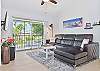 Living with smart TV & cable and sliding doors opening to the large screened in balcony.
