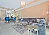 Living with large flat screen TV and sliding doors opening to the screened in balcony.