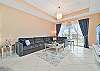 Living with large flat screen TV and sliding doors opening to the screened in balcony.