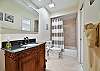 The  guest bathroom offers a shower tub combo