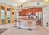 Fully equipped open kitchen with large breakfast bar, dining area with wet bar and additional seating area