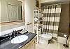 The  guest bathroom offers a shower tub combo