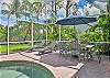 Screened in pool area with outdoor dining, lounge area and seating and outdoor kitchen at the covered lanai