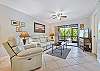 Family room with recliner sofa and chair, a flat screen TV and sliding doors to the screened in lanai and porch.