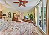 A king size bed and flat screen smart TV in the master bedroom. Sliding doors opening up to the screened in lanai