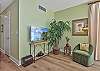 A king size bed and flat screen smart TV in the master bedroom. Sliding doors opening up to the screened in lanai
