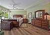 A king size bed and flat screen smart TV in the master bedroom. Sliding doors opening up to the screened in lanai