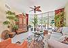 Living area with flat screen smart TV and sliding doors opening to the screened in lanai and terrace