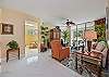 Living area with flat screen smart TV and sliding doors opening to the screened in lanai and terrace