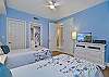 The third bedroom features two twin beds and an en-suite bathroom