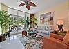 Living area with flat screen smart TV and sliding doors opening to the screened in lanai and terrace
