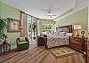 A king size bed and flat screen smart TV in the master bedroom. Sliding doors opening up to the screened in lanai