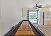 A shuffleboard in the living and sliding doors opening up to the screened in pool area