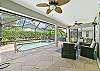 The screened in pool area offers a covered lanai with seating and dining area