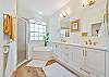  En-suite Primary Bath w/dual sinks, quartz countertops,  soaking tub,  & large tiled shower with seat