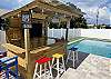 Tiki bar with TV, and string lights. A waterproof blue tooth speaker and rolling cooler included