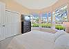 A queen size bed and TV in the guest bedroom. Darkening roller shades are installed in all bedrooms.