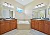 The en-suite primary bathroom features his and her vanity, and a separate shower and tub