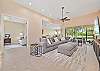 Family room with spacious sectional and TV. Sliding doors open up to the screened in patio