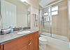 The guest bathroom is equipped with a shower-tub combo