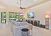 Family room with spacious sectional and smart TV. Sliding doors open up to the screened in patio
