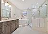 Stunning spa-like en-suite primary bathroom with dual sinks, soaking tub and separate shower