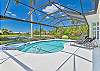 Screened in pool area with heated pool and spa. The panoramic cage offers a stunning lake view