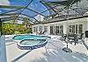 Screened in pool area with heated pool and spa. The panoramic cage offers a stunning lake view