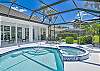 Screened in pool area with heated pool and spa. The panoramic cage offers a stunning lake view