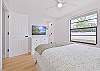 A queen bed and smart TV in the guest bedroom