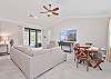 Family room with large smart TV and sliding doors opening up to the screened in pool area
