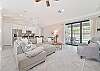 Family room with large smart TV and sliding doors opening up to the screened in pool area
