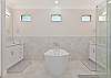 The en-suite primary bathroom features a spacious shower, double vanities and an inviting soaking tub