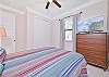 A queen bed and smart TV in the guest bedroom