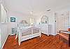 Primary suite with a queen size bed and TV