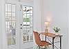 The primary bedroom offers a  cozy office nook by the French doors leading to the pool area
