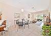 Open living area off the kitchen with dining and sliding doors to the screened in lanai
