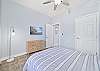 A queen bed and smart TV in the guest bedroom