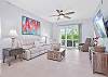 Reclining sofa end seats & chair and large smart TV in the living. Sliding doors provide access to the screened in lanai
