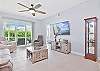 Reclining sofa end seats & chair and large smart TV in the living. Sliding doors provide access to the screened in lanai