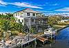 Dockside Dream is a stunning three story modern pool home on a canal with a private dock and Gulf Access, located 1.5 mile from Bonita and Barefoot Beach parking