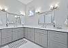 The en-suite primary bathroom is equipped with dual vanities, a soaking tub and spacious shower